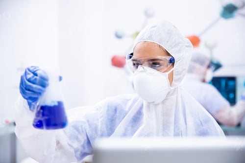 Preview: Chemist in goggles and gloves mask holds a container with blue liquid