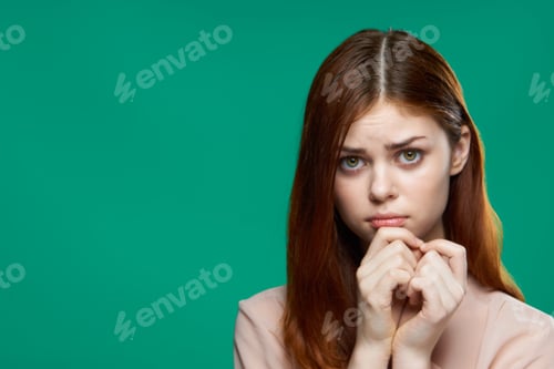 Preview: emotional surprised woman holding hands near face studio lifestyle green background