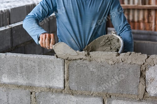 Preview: Bricklayer laying bricks on mortar
