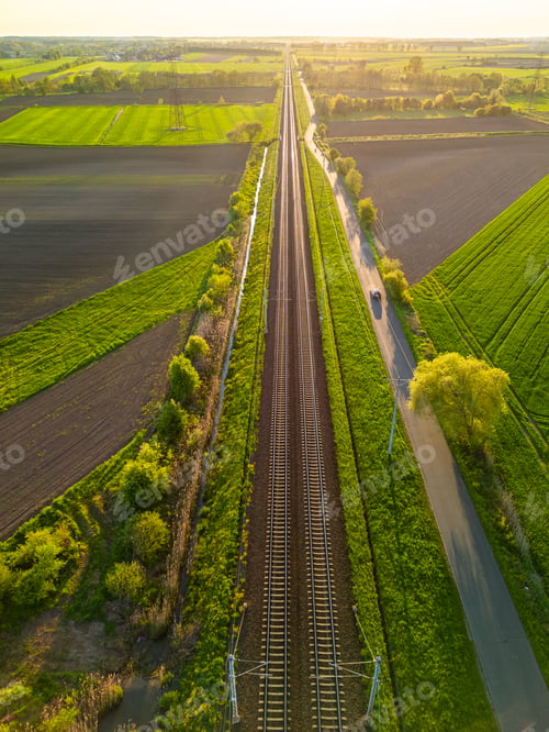 Preview: Aerial view of train tracks in a green field on a sunny day
