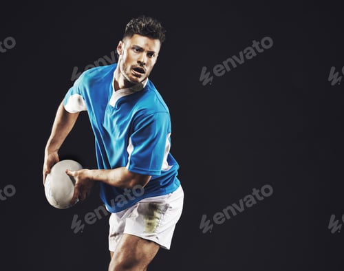Preview: Time for a try. Studio shot of a rugby player passing the ball against a black background.