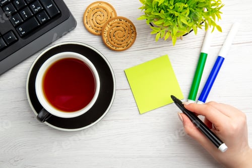 Preview: top view cup of tea with written motivation notes on a white background sweet business keyboard