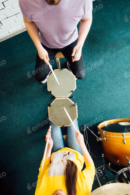 Preview: Top view two drummers sit opposite each other. Playing the practice pads.