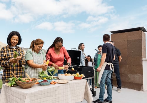 Preview: Multigenerational friends having fun doing barbecue at house rooftop