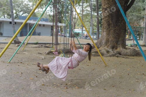 Preview: Woman swinging in an outdoor park.
