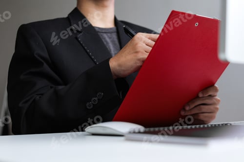 Preview: Professional Man In Sharp Suit Meticulously Reviewing Important Documents On Bright Office Desk