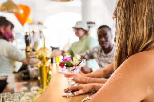 Preview: Young people with colorful cocktails in restaurant