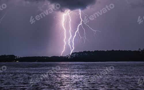 Preview: Beautiful shot of triple close lightning strikes with reflection on the lake