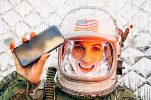 Preview: Beautiful female astronaut with mobile phone.