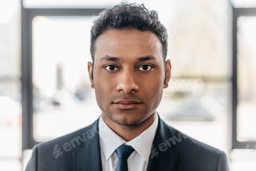 Preview: Close-up portrait of young african american businessman in suit looking at camera