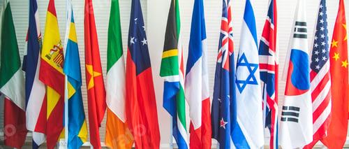 Preview: collection of various flags of different countries standing tall together in a row on a stand