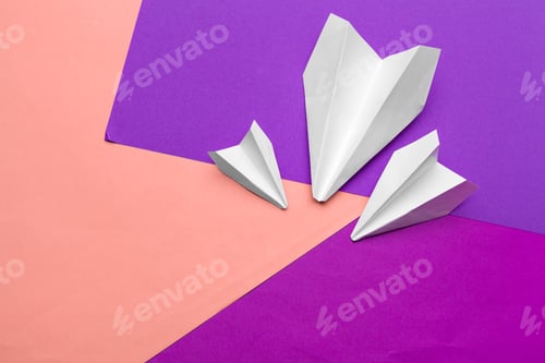 Preview: white paper airplane on a color block paper background