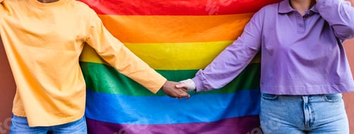Preview: Happy gay couple holding hands while celebrating LGBTQ pride parade