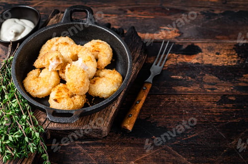 Preview: Fried Breaded Shrimps Prawns in a pan. Dark wooden background. Top view. Copy space