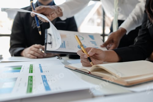 Preview: Mixed group of business people sitting around a table and working, Business team working on a projec
