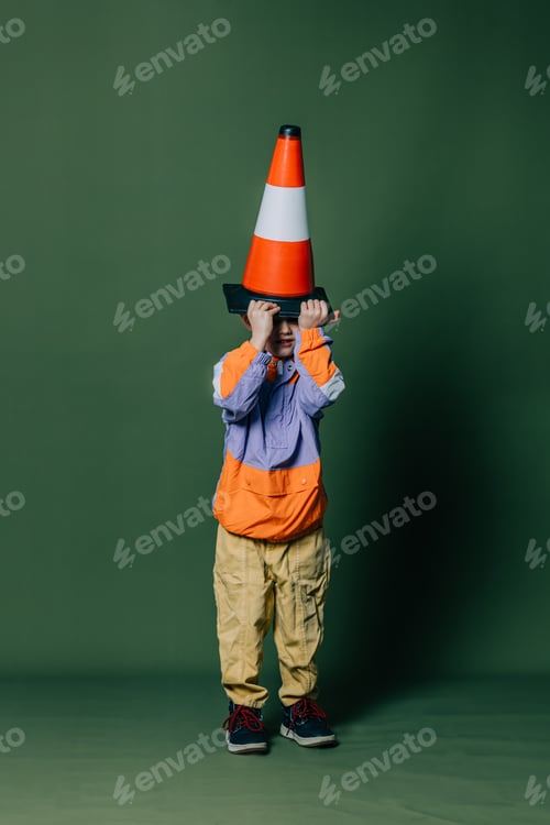 Preview: Stylish little boy with traffic cone on green background