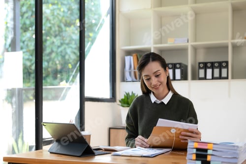 Preview: Portrait of an Asian young business Female working on a laptop computer in her workstation.Business