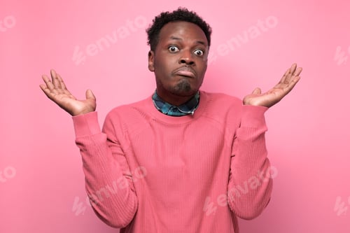 Preview: Young african man in yellow clothes shrugging shoulders