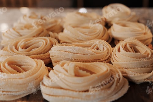 Preview: Delicious raw rolled tagliatelle pasta on table