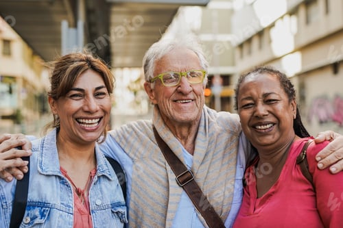 Preview: Multiracial senior friends smiling on camera while waiting at the tram station in the city