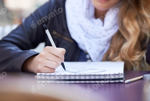 Preview: Sketching in her free time. A young woman drawing in her notepad.