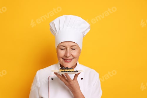 Preview: Professional pastry chef with tart on orange background