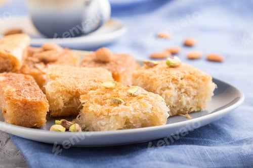 Preview: traditional arabic sweets (basbus, kunafa, baklava) and a cup of coffee on a gray concrete