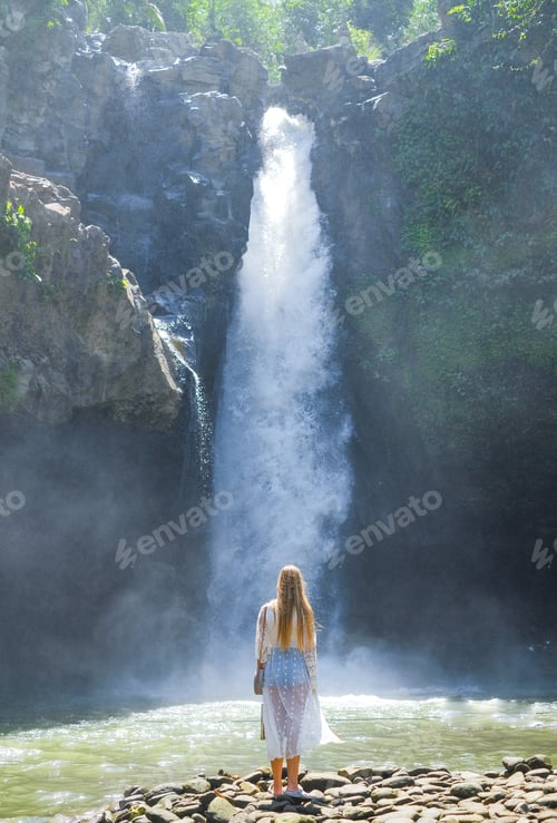 Preview: A girl on the background of a mountain waterfall