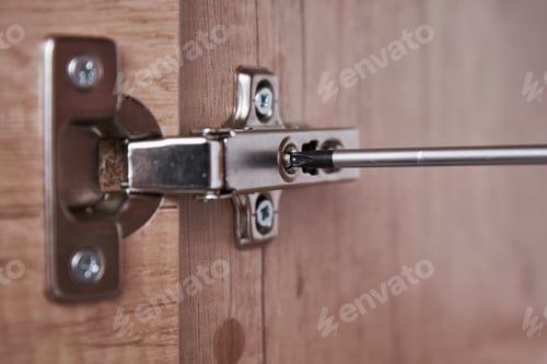 Preview: Hand screwing door hinge on kitchen cabinet