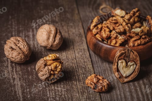 Preview: close up view of walnuts in bowl on wooden surface