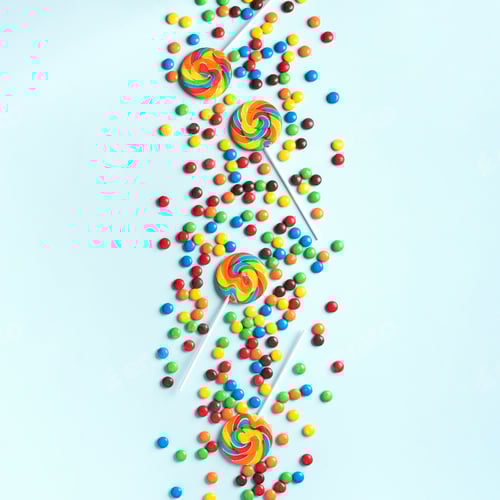 Preview: Multicolored lollipop, rainbow colorful candies on blue background. Coated chocolate sweet pieces