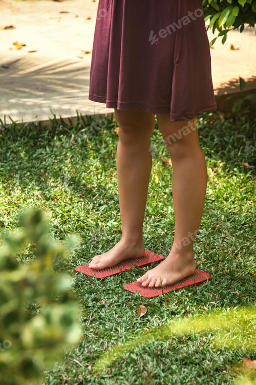 Preview: Woman standing on wooden yoga Sadhu Board with nails outdoors