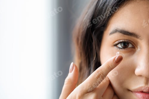 Preview: Ophthalmology Care Concept. Young arab woman putting contact lens in her eye