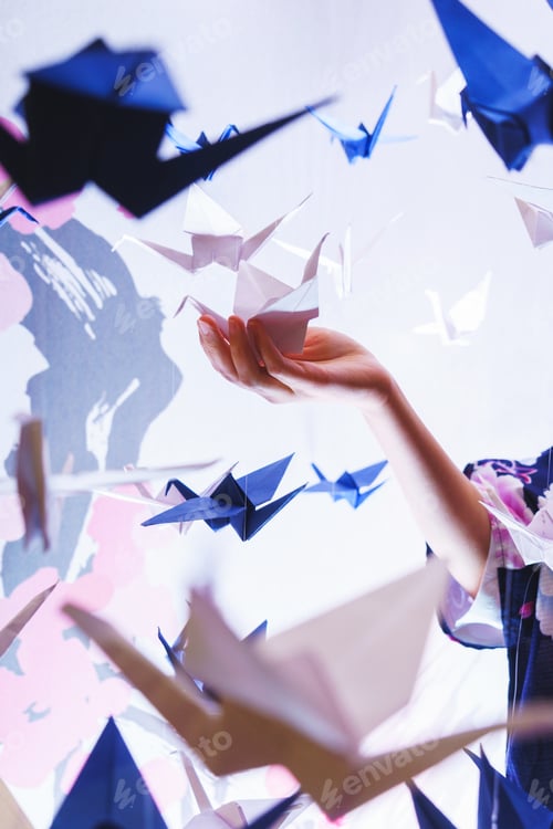 Preview: Girl holding a traditional Japanese origami swan made out of pap