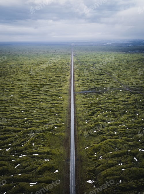 Preview: Aerial view of a long straight road through a green landscape
