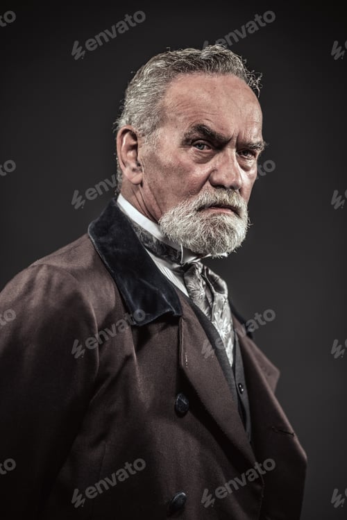 Preview: Vintage Characteristic Senior Man With Gray Hair And Beard. Studio Shot Against Dark Background.