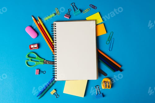 Preview: Composition of notebook with copy space and school tools on blue surface