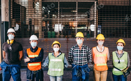 Preview: Group of industrial in protective mask standing in front of closing factory