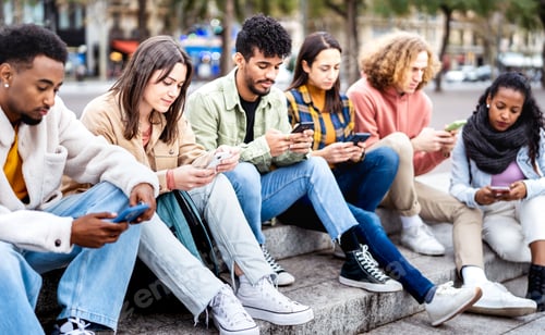 Preview: Bored friends group using mobile smart phone sitting at university college yard