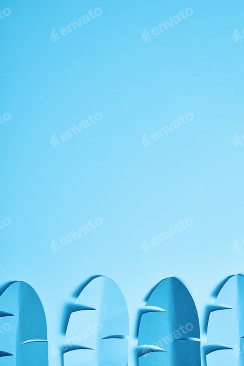 Preview: top view of blue minimalistic paper cut palm leaves on blue background with copy space