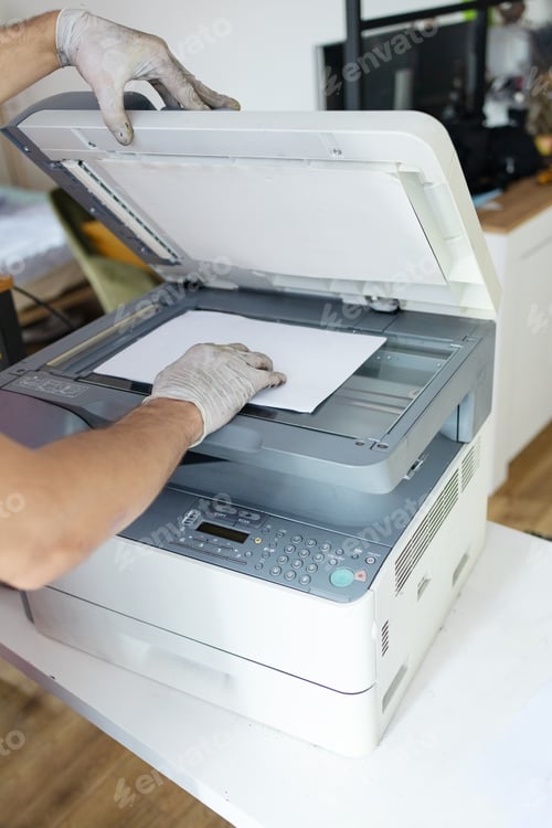 Preview: printer repair technician. A male handyman inspects a printer before starting repairs at the service