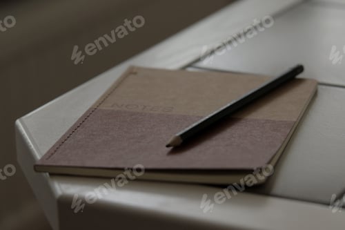 Preview: Brown notebook with a pencil on a table - concept of idea generation