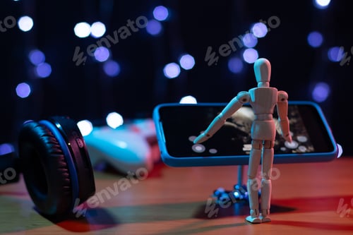 Vista previa: Muñeca articulada de madera jugando a un juego para teléfonos inteligentes. Concepto de jugador