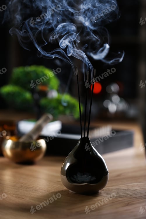 Preview: Incense sticks smoldering on wooden table indoors