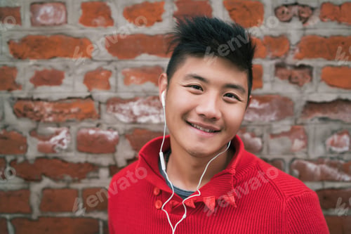 Preview: Asian boy listening to music with earphones.