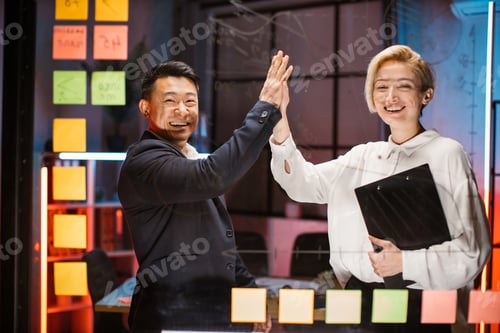 Preview: Business people smiling to camera, giving high five each other, celebrating success