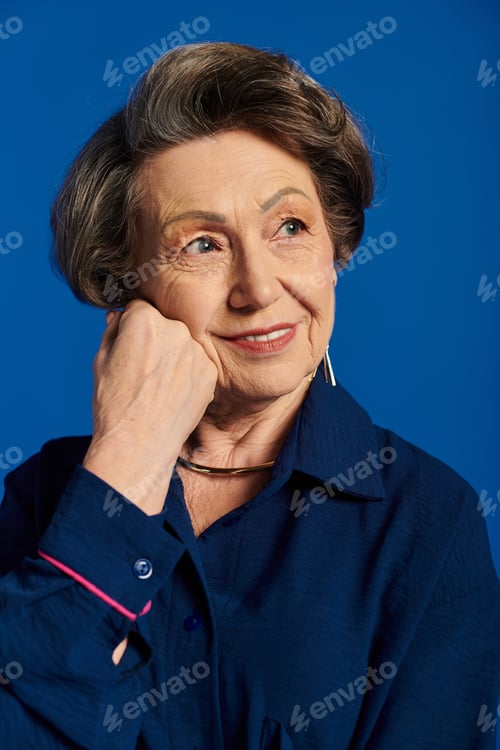 Preview: A beautiful woman in her 60s confidently poses in stylish attire, radiating grace and charm.
