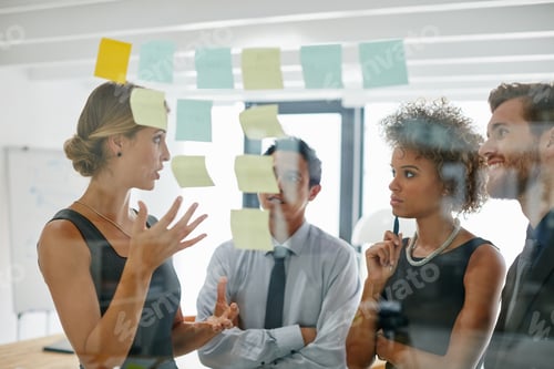 Preview: Shot of coworkers using sticky notes against the wall during a brainstorming session