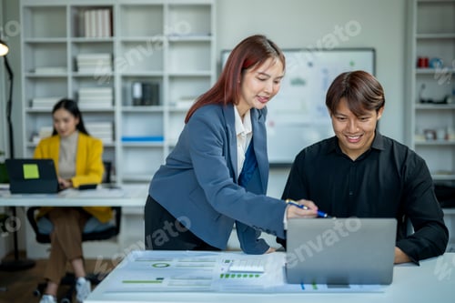 Preview: A woman is helping a man with a laptop.