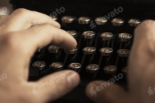 Preview: Young man's hands typing on an antique vintage typewriter